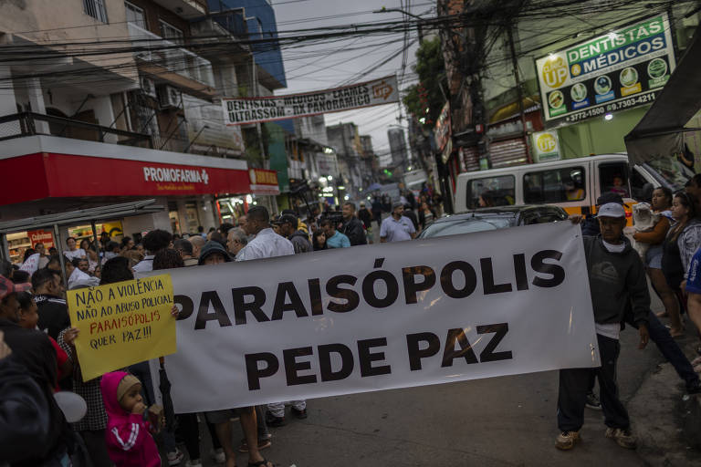 moradores fazem protesto, ao centro há uma grande faixa segurada por várias pessoas em que se lê "Paraisópolis pede paz"