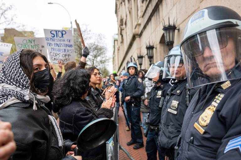 Estudantes e ativistas pró-Palestina protestam em frente a policiais do lado de fora do prédio da Universidade Columbia, em Nova York