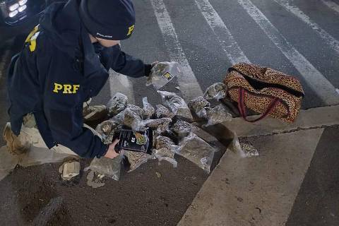 Policial rodoviário federal com os pacotes de skunk encontrados na rodovia Fernão Dias
