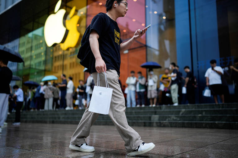 Um homem segura uma sacola com um novo iPhone dentro dela enquanto o novo iPhone 15 da Apple é oficialmente colocado à venda na China, em Xangai, China