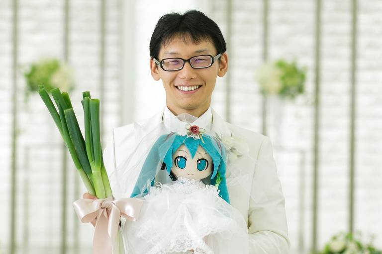 Akihiko com uma boneca de Miku no dia do casamento
