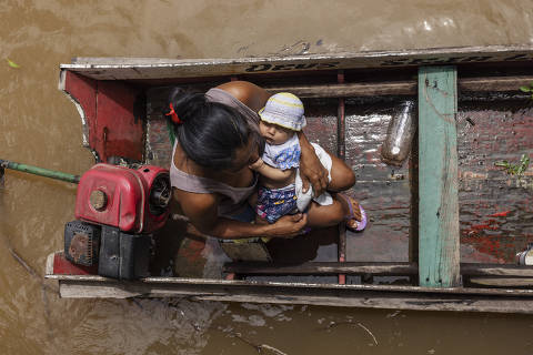 BREVES, PA. 09/04/2024. ESPECIAL MARAJO. Mulher ribeirinha carrega no colo seu filho recem-nascido em uma canoa apos visitar uma Unidade Basica de Saude na  regiao da Boca do Mapua, municipio de Breves. ( Foto: Lalo de Almeida/Folhapress ). COTIDIANO. *** EXCLUSIVO FOLHA***