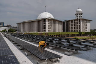 A worker inspects solar panels that provide electrical power to Istiqlal Mosque in Jakarta, Indonesia on Dec. 15, 2023. (Ulet Ifansasti/The New York Times)