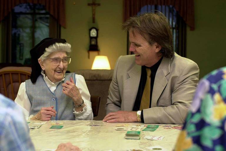 Esther (à esquerda), na foto com 106 anos, rindo ao lado de Snowdon, durante um jogo de cartas no convento