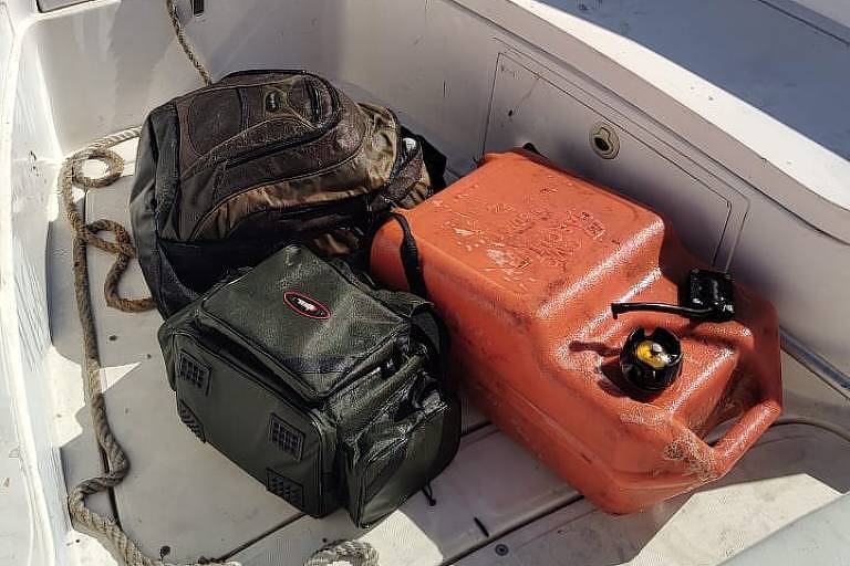 mochilas e um galão no chão do barco