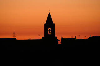 FILE PHOTO: FILE PHOTO: The bell tower of a church is seen during sunset in the village of Montmaneu