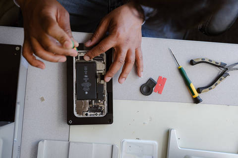 FILE ? Shakeel Taiyab, an independent repair technician, replacing the battery on an iPhone 12 using Apple?s certified repair equipment, in South San Francisco, May 19, 2022. Apple said on Thursday, April 11, 2024, that it w. (Ulysses Ortega/The New York Times) ORG XMIT: XNYT0330