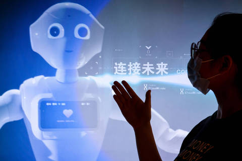 (220526) -- GUIZHOU, May 26, 2022 (Xinhua) -- A staff member introduces a promotion video of 5G AI technology at the exhibition center of the national big data (Guizhou) comprehensive pilot zone in southwest China's Guizhou Province, May 26, 2022. The China International Big Data Industry Expo 2022 opened online on Thursday.
   The exhibition center of the national big data (Guizhou) comprehensive pilot zone has set up a series of installations displaying the changes brought by big data industry to production and people's daily life. (Xinhua/Ou Dongqu)