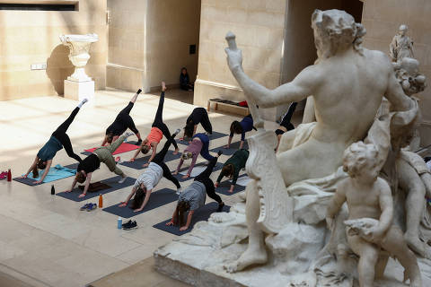 Members of staff of the Louvre Museum and agents of the Creteil choreographic center participate in a yoga class as part of the dress rehearsal of 'Run in the Louvre', a series of sports visits to the Louvre, halfway between a visit guided, dance and sports training designed by French choreographer Mehdi Kerkouche at the Louvre Museum in Paris, France, April 23, 2024. REUTERS/Stephanie Lecocq ORG XMIT: GGG-SLE003