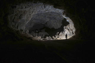 A photo provided by the Palaeodeserts Project shows a researcher exploring the Umm Jirsan Lava Tube system in Saudi Arabia. (Palaeodeserts Project via The New York Times)