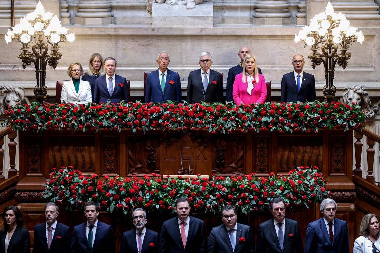 Rebelo de Sousa, o primeiro-ministro português, Luís Montenegro, e membros do governo ouvem hino nacional no Parlamento