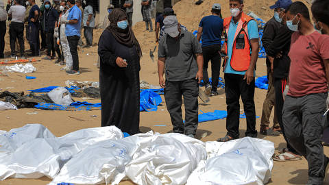 (240423) -- GAZA, April 23, 2024 (Xinhua) -- Workers uncover bodies found at Nasser Hospital in the southern Gaza Strip city of Khan Younis, on April 23, 2024. The Palestinian death toll in the Gaza Strip from ongoing Israeli attacks has risen to 34,183, the Hamas-run Health Ministry said on Tuesday. Mahmoud Basal, spokesman for the Civil Defense Service in the Gaza Strip, said the bodies had been buried collectively by the Israeli army, adding that search operations were underway as thousands of people were still missing in Gaza. The spokesman accused the Israeli army of 