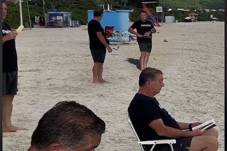 Homem de camisa preta aparece várias vezes na mesma imagem, na praia