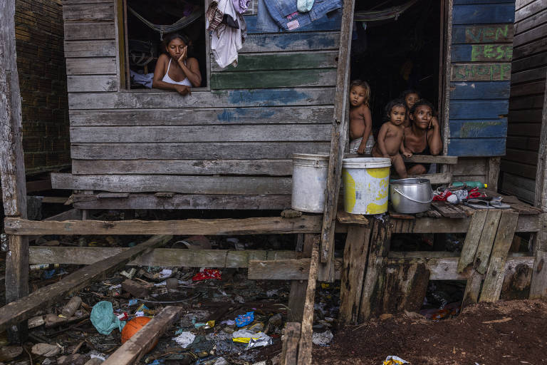 Maria de Fatima da Silva Cardoso conversa da porta de sua casa, cercado pelos seus filhos, no Jardim Tropical, um bairro com moradores de baixa renda de Breves, na ilha do Marajó