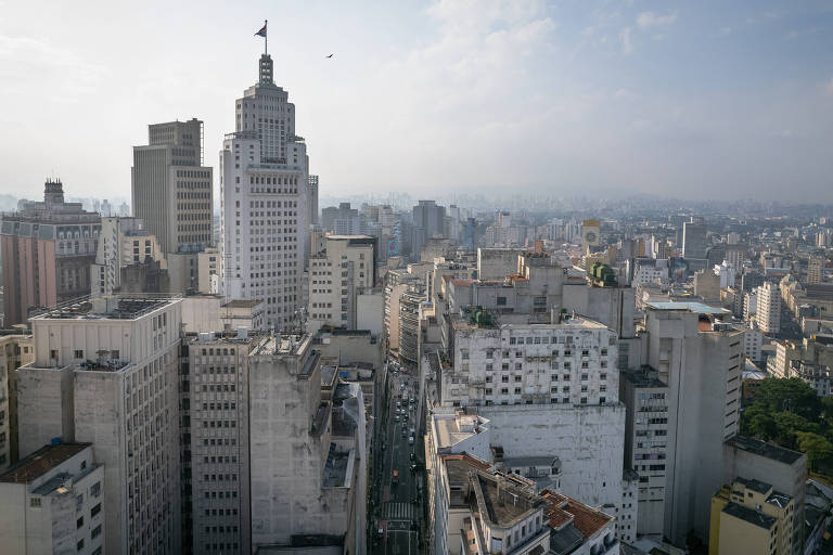 Imagem aérea mostra horizonte de SP repleto de prédios com um se destacando, é o Altino Arantes, que tem uma badeira do estado no topo