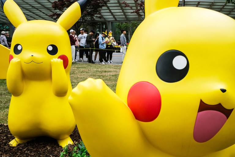 Pessoas fazem fila para visitar estátuas de personagens Pokémon exibidas fora da Lotte World Tower em Seul
