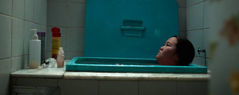 Adolescente nipo-brasileira pensativa em banheira