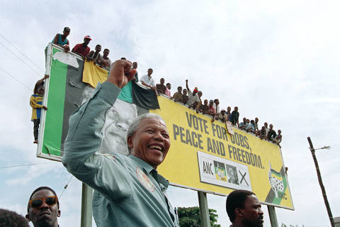(FILES) African National Congress (ANC) President Nelson Mandela greets young supporters atop a billboard in a township outside Durban, 16 April 1994 prior to an election rally. Anti-apartheid hero Nelson Mandela has been seen as a moral compass in his home South Africa, but ten years after his death his legacy is vigorously debated, with some questioning the quality of the country's democracy. (Photo by Alexander JOE / AFP) ORG XMIT: VAC09
