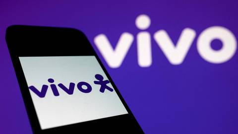 In this illustration photo taken on November 03, 2021, a smart phone screen displays the logo of Vivo telecom company on a Vivo website background in Rio de Janeiro, Brazil. - Brazil will tender its 5G network on November 3, a technology with which it hopes to modernise its productive sector and attract investments of up to 50 billion reais (about USD 9 billion). A total of 15 companies submitted proposals to the National Telecommunications Agency (Anatel), including three large companies that already operate telephony and internet services in the country: Tim (Brazilian subsidiary of Telecom Italia), Vivo (Brazil) and Claro (Mexico). (Photo by MAURO PIMENTEL / AFP)