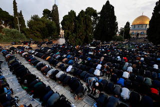 Palestinian Muslims attend Eid al-Fitr prayers which mark the end of Ramadan in Al-Aqsa compound