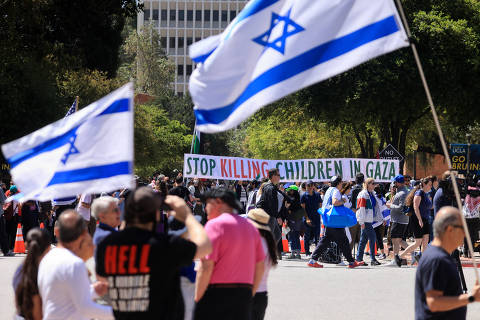 People carry Israeli flags as others hold a banner in support of Palestinians in Gaza, during demonstrations amid the ongoing conflict between Israel and the Palestinian Islamist group Hamas, at the University of California Los Angeles (UCLA) in Los Angeles, California, U.S. April 28, 2024. REUTERS/David Swanson ORG XMIT: LIVE