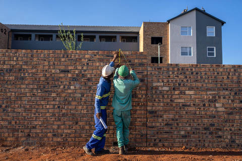 Construction workers inspect a newly built housing project near Johannesburg, South Africa, in March 26, 2024 (Joao Silva/The New York Times) ORG XMIT: XNYT0821