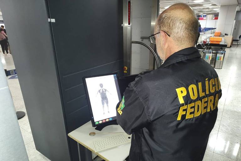 Policial Federal mostra o scanner corporal em uso no aeroporto