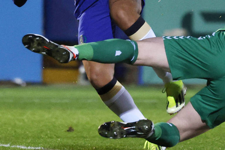 As pernas da atacante Mia Fishel, do Chelsea, que usa calção azul, e da goleira Courtney Brosnan, do Everton, que usa calção verde, chocam-se em duelo da Women's Super League em Londres