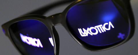 FILE PHOTO: The Luxottica name is reflected in a pair of sunglasses in this photo illustration taken in Rome February 4, 2016. REUTERS/Alessandro Bianchi/File Photo ORG XMIT: FW1