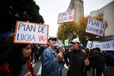 People hold signs, as union members participate in a march during May Day celebrations, in Buenos Aires, Argentina, May 1, 2024. The signs read: 