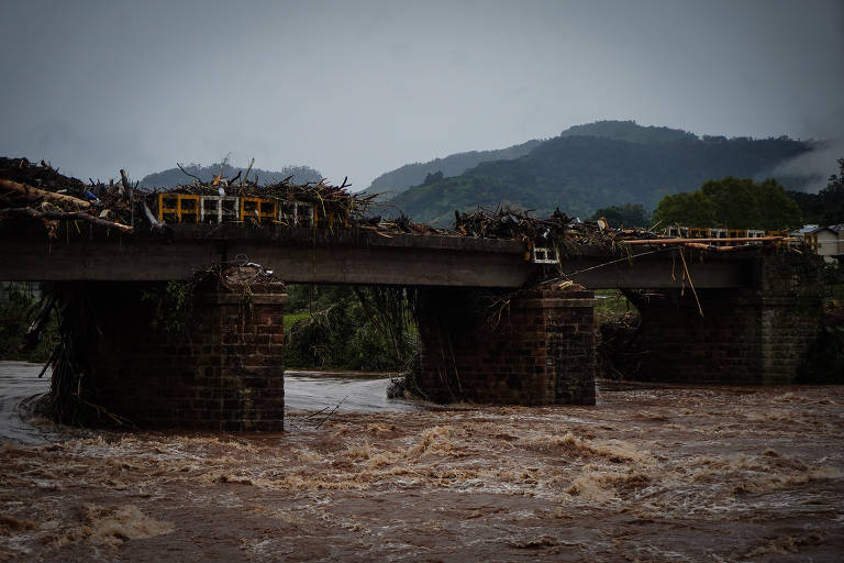 Ponte em Sinimbu cheia de lixo e árvores após a passagem da enxurrada