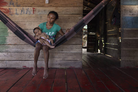 MELGAO, PA. 06/04/2024. ESPECIAL ILHA DO MARAJO. A ribeirinha Francidalva Mendes Santos, 37, com seus filhos no interior de sua casa na regiao do rio Mujirum, no municipio de Melgaco. Francidalva sofreu violencia obstetrica durante o parto de seu filho Adailson,8, que nasceu com paralisia cerebral. ( Foto: Lalo de Almeida/Folhapress ). COTIDIANO. *** EXCLUSIVO FOLHA***
