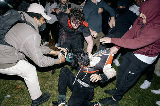 A pro-Palestinian protester is beaten by counter-protesters during violent clashes at the protest encampment on the UCLA campus in Los Angeles early Wednesday morning, May 1, 2024. (Mark Abramson/The New York Times)