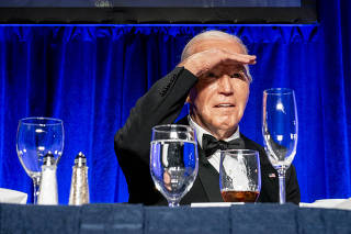 President Joe Biden tries to get a better look at the crowds before he gives remarks during the White House Correspondents' Association Dinner at the Washington Hilton in Washington, on April 27, 2024. (Haiyun Jiang/The New York Times)