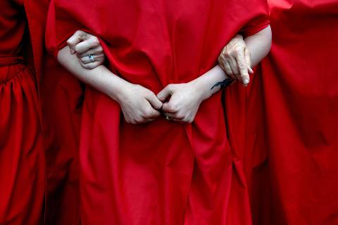 Abortion rights activists, dressed in an outfits from The Handmaid's Tale, lead protestors during a march in Denver, Colorado on June 27, 2022, four days after the US Supreme Court striked down the right to abortion. (Photo by Jason Connolly / AFP)