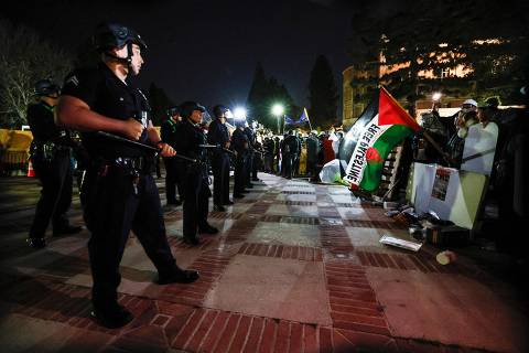 Pro-Palestinian students stand their ground after police breached their encampment the campus of the University of California, Los Angeles (UCLA) in Los Angeles, California, early on May 2, 2024. Police deployed a heavy presence on US university campuses on May 1 after forcibly clearing away some weeks-long protests against Israel's war with Hamas. Dozens of police cars patrolled at the University of California, Los Angeles campus in response to violent clashes overnight when counter-protesters attacked an encampment of pro-Palestinian students. (Photo by Etienne LAURENT / AFP)