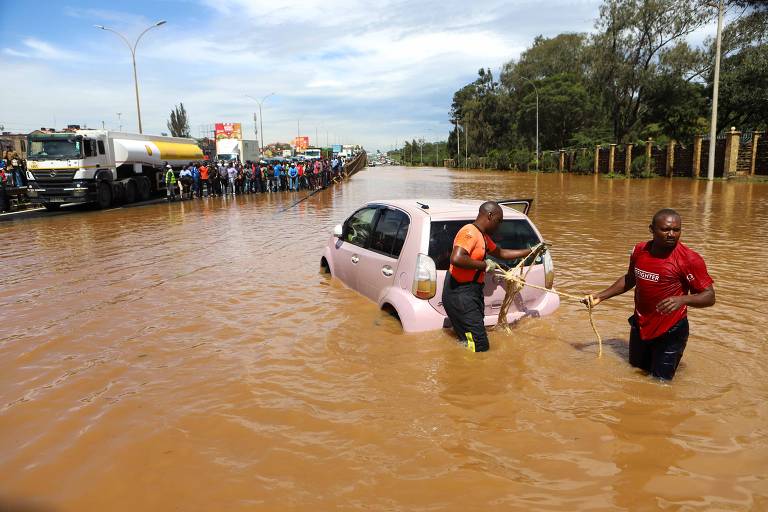 Pessoas puxam carro submerso nas enchentes em Nairóbi, capital do Quênia. Ao menos 188 pessoas morreram em enchentes e deslizamentos de terra causados por fortes chuvas no país