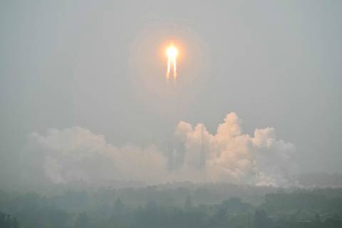TOPSHOT - A Long March 5 rocket, carrying the Chang'e-6 mission lunar probe, lifts off as it rains at the Wenchang Space Launch Centre in southern China's Hainan Province on May 3, 2024. China is set on May 3 to launch a probe to collect samples from the far side of the Moon, a world first as Beijing pushes ahead with an ambitious programme that aims to send a crewed lunar mission by 2030. (Photo by HECTOR RETAMAL / AFP)