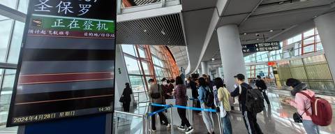 Passageiros embarcam no voo CA897 da Air China, no Aeroporto Internacional da Capital em Pequim, em 28 de abril de 2024