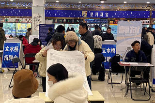 FILE PHOTO: People attend a job fair in Beijing