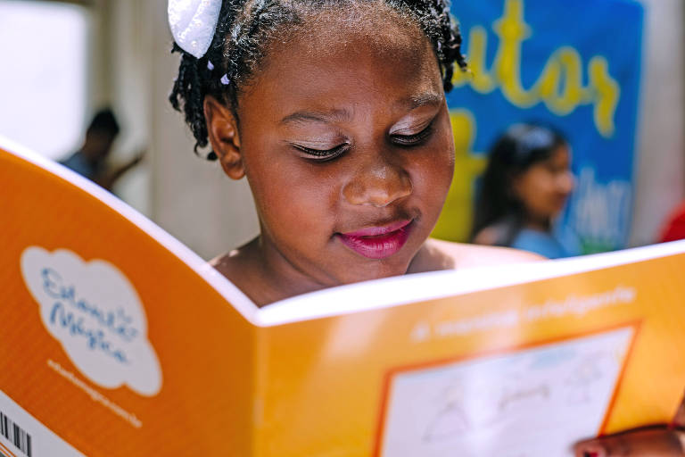 Menina lendo livro de capa laranja