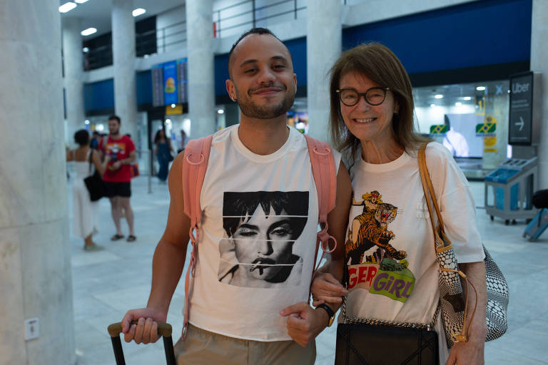 rapaz e mãe com camisetas da madonna em aeroporto