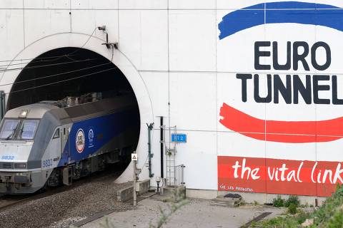 (FILES)- An April 10, 2014 file photo shows a EuroTunnel train coming out of the Channel Tunnel, owned by EuroTunnel, on in Coquelles, northern France.  The company that runs the cross-Channel rail tunnel said on July 22, 2015 it was seeking 9.7 million euros ($10.67 million) from the British and French governments in compensation for disruption caused by illegal migrants.  Eurotunnel said it was seeking the compensation after it incurred a security bill of 13 million euros in the first half of 2015 trying to stop migrants crossing to England from France. AFP PHOTO / DENIS CHARLET ORG XMIT: 850