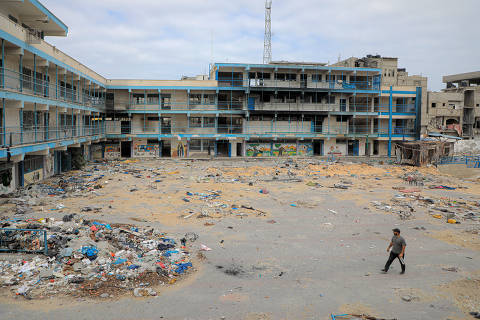 (240502) -- KHAN YOUNIS, May 2, 2024 (Xinhua) -- A man walks past a school building affiliated with the United Nations Relief and Works Agency for Palestine Refugees in the Near East (UNRWA) in the southern Gaza Strip city of Khan Younis, on May 2, 2024. (Photo by Rizek Abdeljawad/Xinhua)