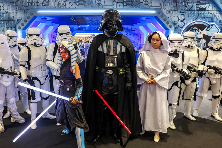 Homem fantasiado de Darth Vader no centro da imagem com outras pessoas fãs de Star Wars, em Bangkok, na Tailândia