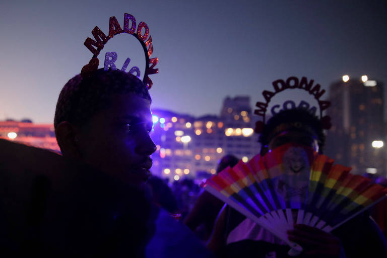 Fãs usam acessórios costumizados enquanto esperam na praia de Copacabana para assistir ao show gratuito de Madonna no Rio de Janeiro.