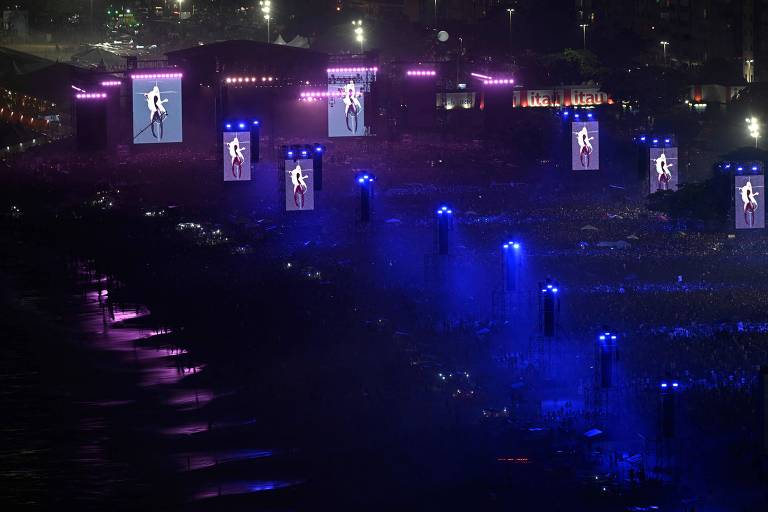 Imagem aérea mostra o palco antes do show da estrela pop norte-americana Madonna na praia de Copacabana, no Rio de Janeiro; imagem da Madonna nos telões.