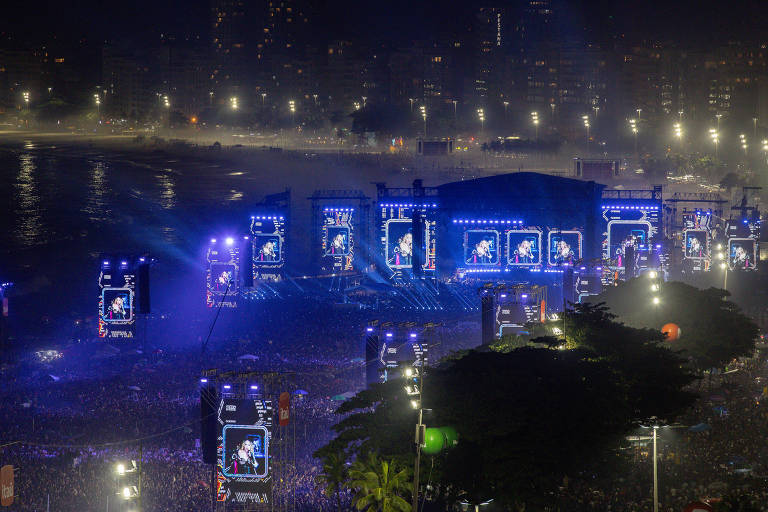 imagem aérea mostra telões e público durante o show da cantora Madonna nas areias da praia de Copacabana, na zona sul do Rio de Janeiro.