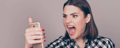 A portrait of an angry young woman disappointed with the news from her work and screaming on the phone. Credit Deagreez / Fotolia