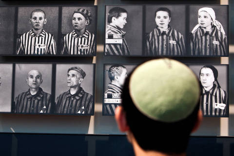 FILE PHOTO: A visitor looks at pictures of Holocaust victims at Yad Vashem's Holocaust History Museum in Jerusalem April 18, 2012. REUTERS/Nir Elias/File Photo ORG XMIT: FW1